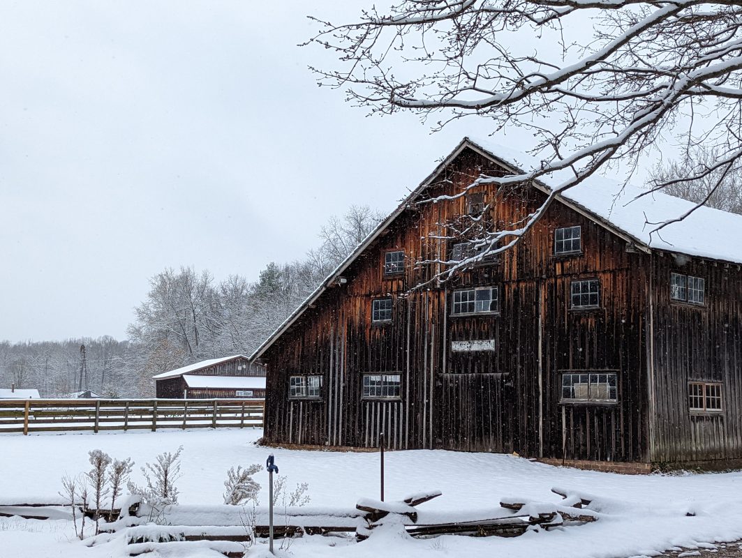 dark wooden barn covered in snow